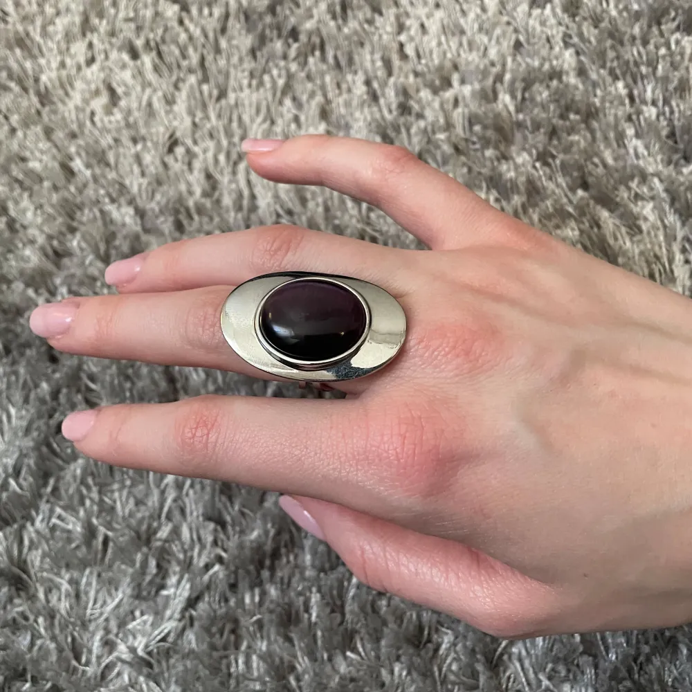Säljer en elegant silverring med en stor oval lila sten i mitten. Den är i mycket bra skick och går att spänna ut och in💜. Asusteet.