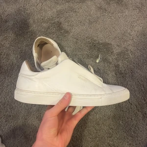 Arigato skor Zip vit Herr - Hej! Säljer dessa snygga vita Axel Arigato skor i bra skick! Använda och det syns men fortfarande mycket liv i sig! Skick enligt bilder! Storlek 42! Skriv för intresse! 👍🏻