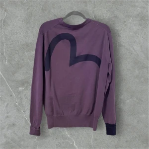 Lila evisu kofta  - Snygg lila kofta från evisu med fickor på framsidan. Längd: 63 cm, bredd: 43 cm. Står storlek L men passar M. Finns på folkungagatan 142! 