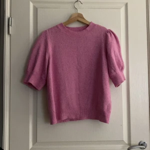 Rosa tröja från Vero Moda - Säljer en söt rosa tröja från Vero Moda med puffiga korta ärmar. Tröjan har en rund halsringning och är gjord i ett mjukt material som känns skönt mot huden. Perfekt för en stilren och bekväm look. 💖Obs! Knappt använd 