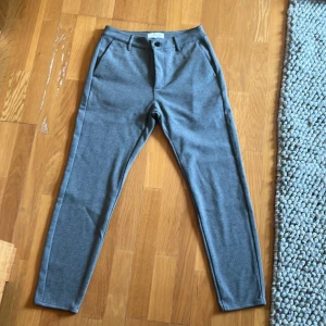 Grå kostym byxor från Studio Total - Grå byxor från Studio Total i storlek M. Byxorna har en normal passform med en knapp och dragkedja framtill. De har också fickor både fram och bak.