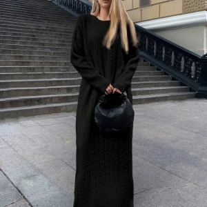 Svart stickad långklänning - Snygg och bekväm svart stickad långklänning med långa ärmar. Perfekt för kyligare dagar och ger en stilren look. Passar bra med accessoarer för att lyfta outfiten.