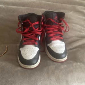 Nike Air Jordans i svart, vitt och rött - Säljer ett par klassiska Nike Air Jordans i svart, vitt och rött. Skorna har en ikonisk design med snörning och den välkända Nike-loggan på sidan. Perfekta för dig som vill ha en stilren och sportig look. Skorna är även i väldigt bra skick 