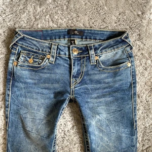 Helt nya! Blå jeans från True Religion stl W24 L32 - Snygga blå jeans från True Religion med låg midja och utsvängda ben. De har dekorativa sömmar och guldiga knappar. Perfekta för en avslappnad stil. Endast provade💕