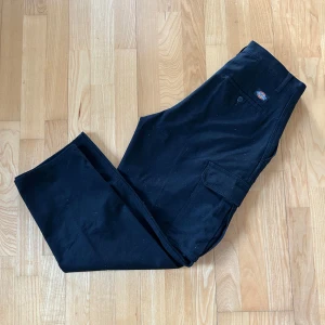 Svarta byxor från Dickies - Snygga svarta cargopants från Dickies. Har en loose passform. Använda fåtal gångar i mycket bra skick. Storlek: 30/30
