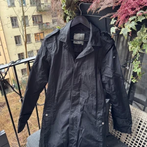Svart trenchcoat från J.Lindeberg - Mycket fin inför de regniga dagarna som våren brukar bjuda oss på 🤩  •Skick: 9/10 få tecken på användning   •storlek📏: M kolla mått på sista bild  •Nypris/Butikspris:💰3999kr   Köp gärna i bundles för att underlätta i frakt och på detta vis blir jag mer flexibel i pris! Våga buda! 🚚🤝