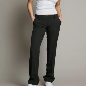 Svarta kostymbyxor från Bikbok - Snygga svarta kostymbyxor med en klassisk straight passform. Byxorna är i modellen Vera och är perfekta för en stilren look. De är tillverkade i ett bekvämt material och har diskreta fickor. Str 38.