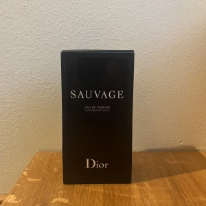 Sauvage Eau de Parfum från Dior - Säljer en elegant och maskulin Eau de Parfum från Dior, Sauvage. Flaskan rymmer 100 ml och kommer i en stilren svart förpackning. Perfekt för den som vill ha en tidlös och kraftfull doft.