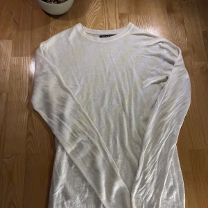 Vit stickad tröja  - Säljer en stilren vit stickad tröja från primark Tröjan har en klassisk rund hals och långa ärmar, perfekt för kyligare dagar. Passar bra till både jeans och kjol. Perfekt basplagg i garderoben!