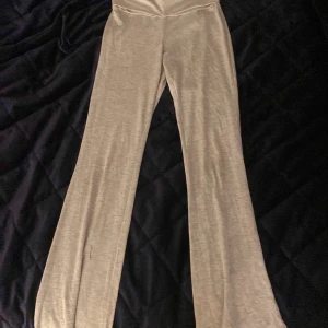 Gråa yoga pants från H&M - Säljer ett par bekväma beige byxor från H&M. De har en loose passform med en bredare bootcut-stil. Perfekta för en avslappnad look.