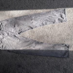 Grå jeans från Jack & Jones - Säljer ett par grå jeans från Jack & Jones med en relaxed passform. Perfekta för en avslappnad stil. De har en klassisk design med fem fickor och knappgylf.