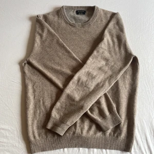 Beige kashmirtröja från Massimo Dutti - Säljer en elegant beige kashmirtröja med rund hals och långa ärmar.  Ny priset är 1700 😵Mitt pris 599 😮‍💨 Har ett pytteliten hål som är lite igensytt (inte det bästa gjort) Hör av dig vid några funderingar, Priset är inte hugget i sten! 