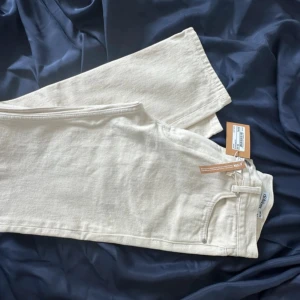 Beige jeansbyxor från Dobber - Snygga och sköna vit/beige (light ecru) jeansbyxor från Dobber i en straight fit o strl. 30/32 Byxorna har en klassisk femficksdesign och är tillverkade i ett mjukt bomullsmaterial (100%). Perfekta för en stilren look. 