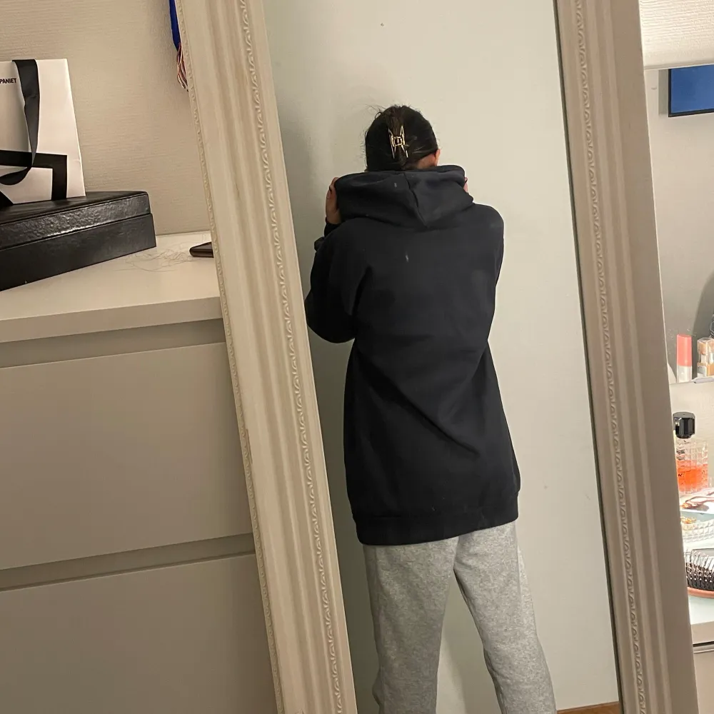 Säljer en blå lång hoodie med en bekväm och avslappnad passform. Den har en klassisk design med dragsko i huvan och en stor ficka framtill. Perfekt för en casual look.. Hupparit & Collegepaidat.
