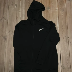 Svart zip-up  DRI-FIT hoodie från Nike - Svart zip-up  DRI-FIT hoodie från Nike.                      Storlek M.                                                                            Oanvänd