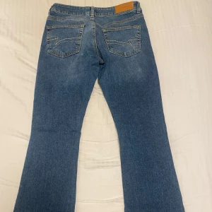 Blå bootcut jeans - Snygga blå bootcut jeans från junkyard i storlek M. Lite slitet längst ner.