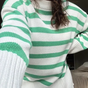 Grön och vit randig stickad tröja - Säljer en mysig stickad tröja med gröna och vita ränder. Tröjan har långa ärmar och en bekväm passform. Perfekt för kyligare dagar!