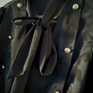 Svart skjorta  - Svart skjorta med rosett och knappar 