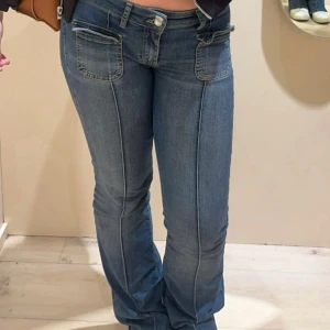 Blå jeans med fickdetaljer - Mycket bra skick, endast lite slitna nere vid hälarna men inget som syns när man har på sig de. Snygga blå jeans med fickdetaljer fram. De är Lågmidjade och bootcut. Från Nelly i storlek 38 men skulle säga att de passar både 36 och 40 då de formar sig bra 🥰nypris 700 