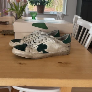 Vita och gröna sneakers från The Gallerist - Skor från The Gallerist. Säljer pga dom är för små och tröttnat. Skick 6/10  Nypris 2000kr.OBS sulorna är lite trasiga men går att fixa med limm.OBS BOX INGÅR INTE