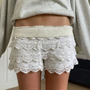 Beiga virkade spetsshorts - Superfina vita shorts med bred resår i midjan och flera lager virkad spets med scallop-kant. De har en romantisk och bohemisk vibe, perfekta för varma dagar. Shortsen är midwaist och har en luftig passform som känns både trendig och bekväm. Storlek s💕 OBS kan posta senast idag elller imorgon (17-18 juli) åker iväg sedan🩷🩷