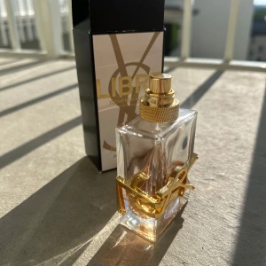 Yves Saint Laurent Libre parfym - Säljer en ANVÄND ikonisk YSL Libre parfym i snygg, genomskinlig glasflaska med guldiga detaljer och logga. Innehåller ungefär 35/40% parfym kvar i flaskan. 