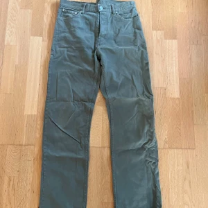 Weekday space khaki - Snygga gröna jeans med rak passform och klassisk femficksdesign. Byxorna har normal midja och är tillverkade i ett mjukt bomullsmaterial som känns skönt mot huden. Perfekta för en avslappnad men stilren look. 30/32