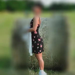 Svart blommig kortklänning med breda axelband - Supersöt svart kortklänning med orange och gula blommor, breda axelband och figurnära passform. Perfekt för varma dagar och har en smickrande siluett. Klänningen har dragkedja i sidan och är ärmlös. Materialet känns lätt och luftigt. Från H&M