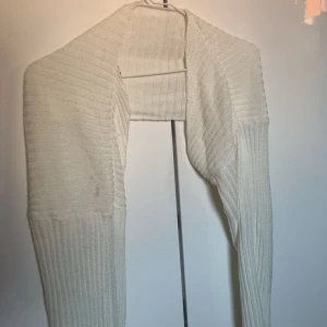 Vit kort stickad kofta🤍 - Säljer en vit stickad kofta med ribbad struktur🤍Perfekt att slänga över en topp eller en klänning för en chill och stilren look. Skönt när de blir lite kallare på kvällen💓