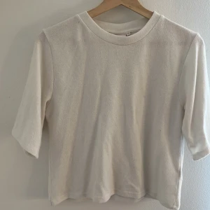 Vit kortärmad tröja från Nelly - Enkel och stilren vit tröja från Nelly i storlek XS. Tröjan har rund halsringning och korta ärmar, perfekt för en clean och avslappnad look. Materialet känns mjukt och bekvämt mot huden.