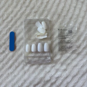 Vita lösnaglar med fil och lim - Säljer ett set med vita lösnaglar i olika storlekar, perfekt för att fixa snygga naglar snabbt. Paketet innehåller även en liten nagelfil och lim. Naglarna har en klassisk, stilren form och är gjorda av plast. Allt kommer i originalförpackning.