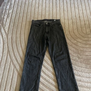 Svarta raka jeans från Valinets - Säljer ett par svarta jeans från Valinet med klassisk femficksdesign och raka ben. Jeansen har normal midja och är tillverkade i slitstarkt denimtyg. Perfekta för dig som gillar en clean och tidlös look.