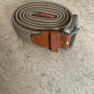 Flätad bälte  - Säljer en fet bälte från Jack and Jones, Den är 105 cm lång och är i ny skick. 