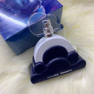 Ariana Grande parfym Cloud - Parfymflaska från Ariana Grande i modellen Cloud. Flaskan är vit och blå med en unik molnformad bas och ett genomskinligt moln som lock. Snygg och lekfull design som sticker ut på hyllan. Perfekt för dig som gillar Ariana Grande och coola flaskor.