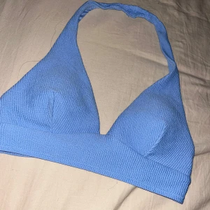 Blå bikiniöverdel med halterneck - Snygg blå bikiniöverdel med halterneck och ribbad struktur på utsidan. Triangelformade kupor och bred resår under bysten för extra stöd. Enkel att matcha med olika underdelar.💕 passar en som är både m och s. Priset går att göra något åt💕
