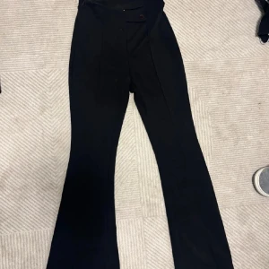 Svarta bootcut kostymbyxor - Snygga svarta kostymbyxor med hög midja och bootcut-ben. Klassisk design med pressveck framtill och knappstängning i midjan. Vet ej om dom är XS eller S men dom bör passa båda👍🏻