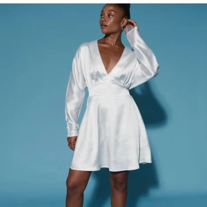 Vit satin klänning med v-ringning - Superfin vit kortklänning i satin från Gina tricot! med lång ärm, markerad midja och djup v-ringning. 🫧🫶🏼 