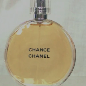 Chanel Chance parfym - Chanel Chance parfym i en rund, transparent glasflaska med ljusgul vätska och stilren svart text. Flaskan har en silvrig spraytopp och genomskinligt lock. En klassisk och elegant doft som verkligen sticker ut i badrumshyllan.