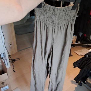 Bruna linbyxor från Kappahl - Snygga bruna flowy linbyxor från Kappahl i storlek XS. Byxorna har hög smockad midja och vida ben för en chill och luftig känsla. Perfekta för varma dagar och riktigt sköna att bära. Styla med en crop top eller oversized skjorta för en laidback vibe.