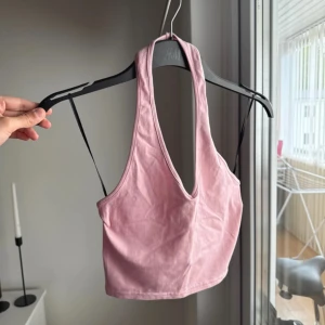 Ljusrosa croppad linnetopp H&M - Säljer en ljusrosa croppad linnetopp från H&M med djup urringning och brottarrygg. 