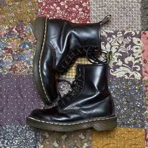 Dr. Martens  - Klassiska svarta Dr. Martens boots i skinn med åtta håls snörning och den ikoniska gula sömmen runt sulan. Grov platt sula och dragflik med logga baktill, väldigt bra skick och mycket sparsamt använda👌👌👌