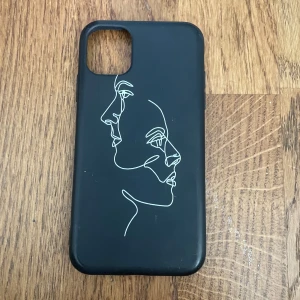 Mobilskal med ansikte - Säljer mitt svarta mobilskal till iPhone 11 med två ansikten! Säljer pga den inte passar min nuvarande telefon! 