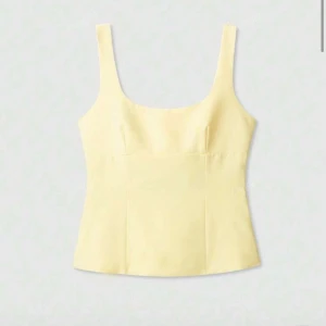 Gul linnetopp med rosett i ryggen - Supersöt ljusgul linnetopp med breda axelband och en stor rosett i ryggen. POSTAR INOM 24H!!