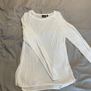 Vit långärmad tröja från Soulmate - En stilren vit långärmad tröja från Soulmate i storlek M. Tröjan är tunnstickad med rund halsringning och har en enkel, clean look som passar perfekt till jeans eller kjol. Materialet känns mjukt och lätt, vilket gör den skön att bära under flera säsonger.