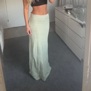 Ljus stickad långkjol - Supersnygg ljusgrön stickad långkjol med rak passform och diskret struktur i materialet. Kjolen är högmidjad och sitter tajt upptill men faller snyggt längs benen. Aldrig använd 