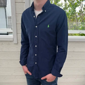 Marinblå Ralph lauren skjorta - Säljer jätte fin Ralph lauren skjorta i jätte bra skick, inga tecken på användning, modellen är slim fit, bara att skriva vid funderingar och det postas inom 48h