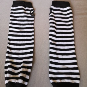 Randiga armvärmare - Ett par långa armvärmare med klassiskt svartvitt randigt mönster. Dem går jämt under armbågarna har jag för mig. Använda fåtal gånger och defekter är minimala till 0. Behöver bara tvättas vilket köparen får fixa.