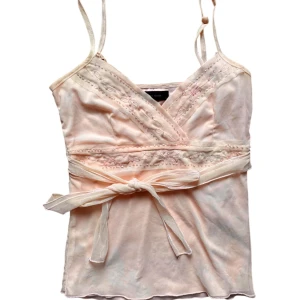 Vintage Ljusrosa/orange linnetopp med paljetter - Linne från gammal vero moda. med pärlor. Rosa/aprikos färg. Strl L på lapp men mer en XS-S i storlek. Enda defekt är två ganska ljusa fläckar på ena knytbandet där bak. Men syns inte när den är knuten. Ksk försvinner i tvätt. 