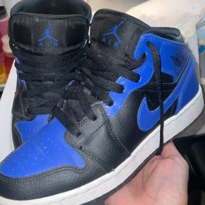 Nike Air Jordan 1 Mid Royal/Black 36.5 /37 - Nike Air Jordan 1 Mid i färgen Hyper Royal/Black. Skorna har svart och blått skinn. Skriv om ni undrar något💕