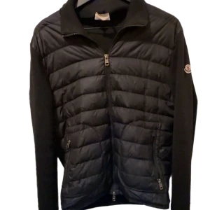 Moncler Maglione Tricot Cardigan  - Säljer min Moncler Maglione Tricot Cardigan i svart, storlek L. 100 % äkta  syns på loggan, dragkedjor och innerlappar. Använd ett antal gånger men i fint skick. Ett mindre hål är lagat (syns på bild), påverkar ej användning eller helhetsintryck. Kvitto, box och tags finns ej kvar ä därav priset: 5 000 kr. Legit check är självklart okej. Hör av dig vid intresse eller om du vill ha fler bilder. Bud kan diskuteras